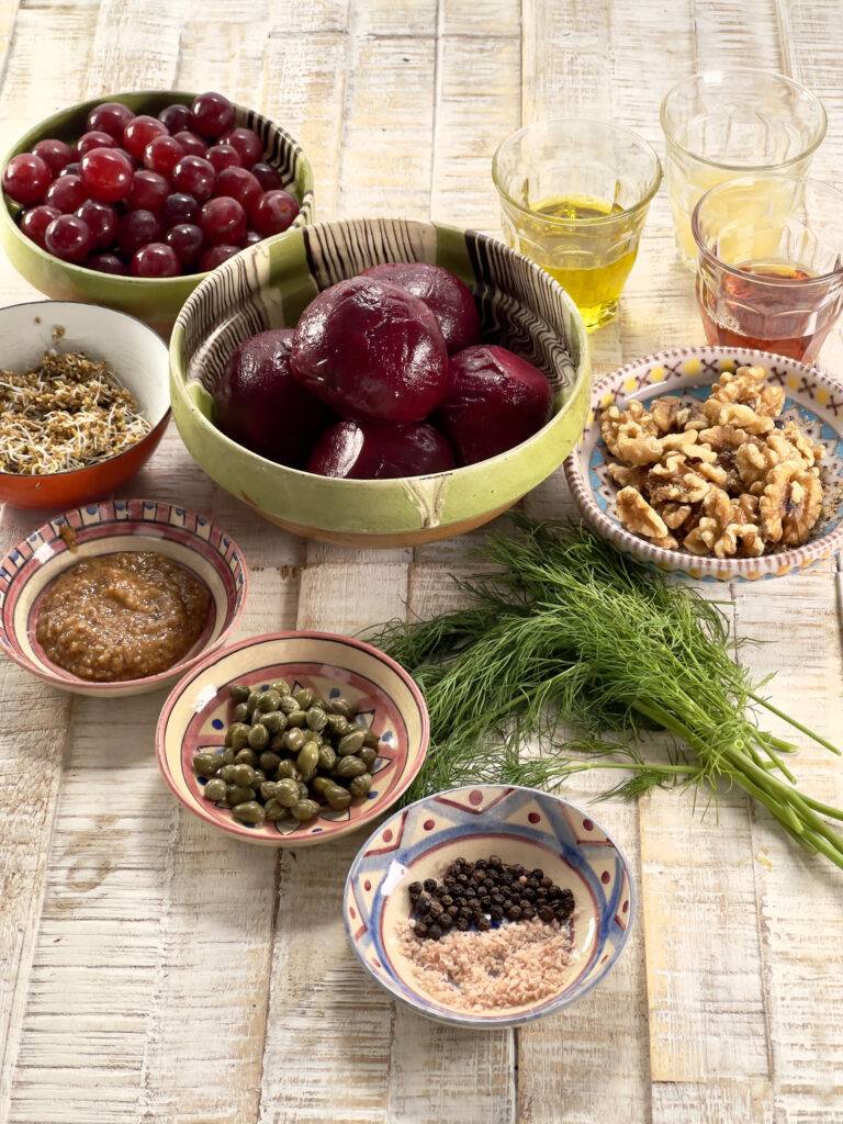 Ingredients for beet salad with grapes and walnuts in beautiful small bowls