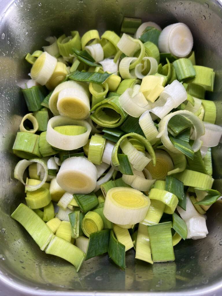 Rinsed and cut Leek in a stainless steel bowl
