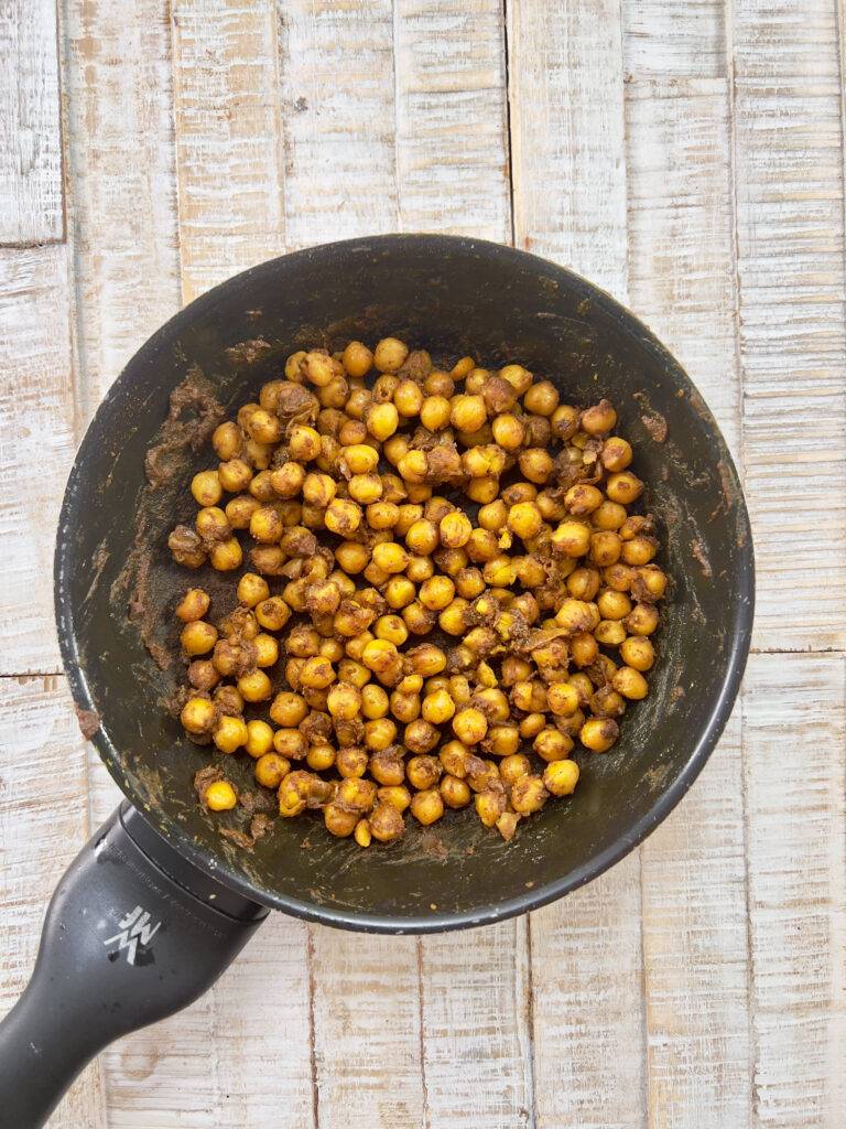 Spice-coated chickpeas presented in the pan.