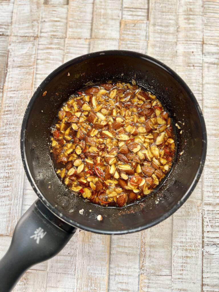 Almonds, garlic, chilli and spices frying in olive oil.