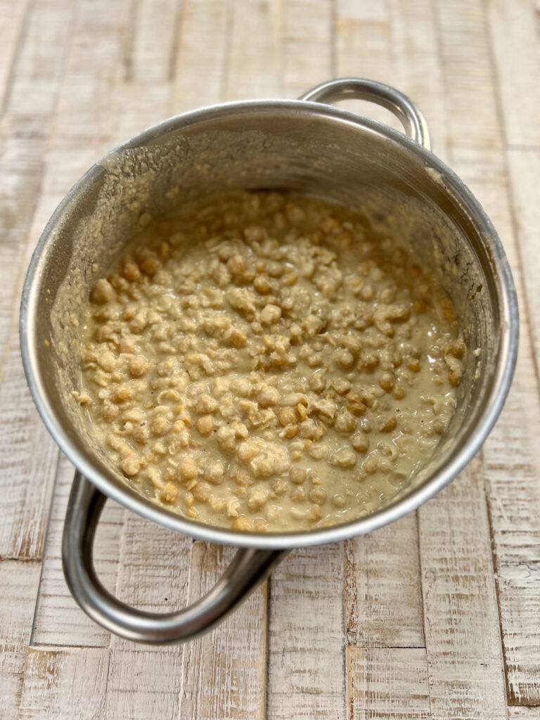 Mashed chickpeas with tahini and lemon juice in stainless steel pot