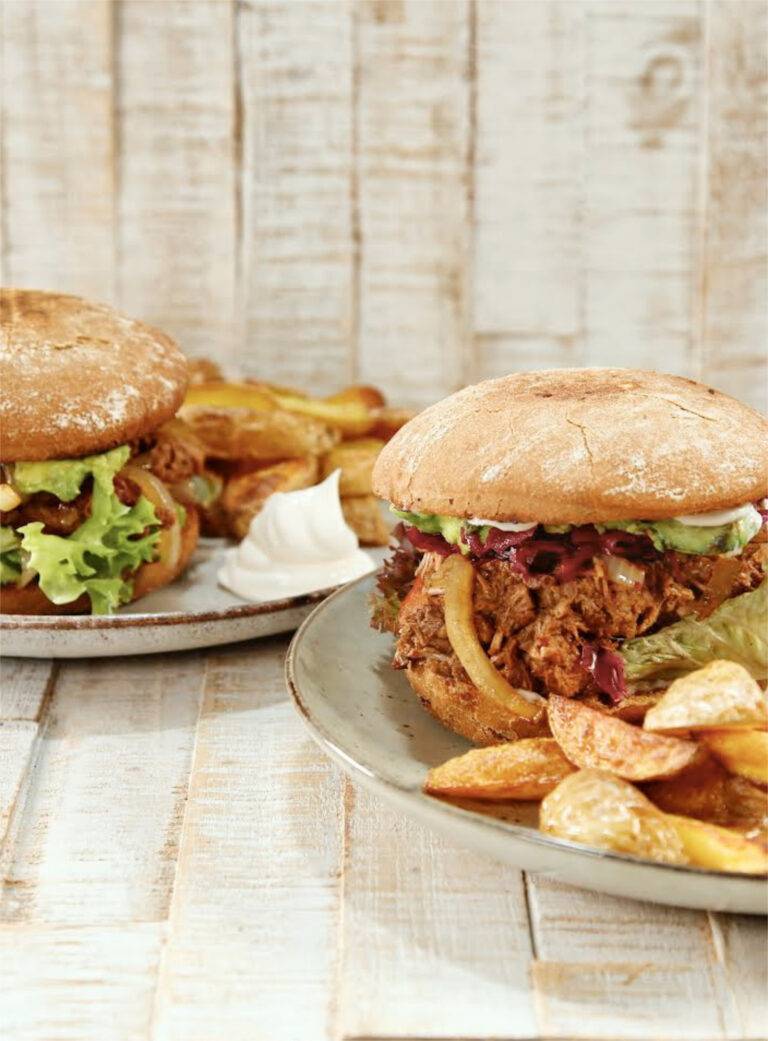 Pulled jackfruit burgers plated with potato wedges