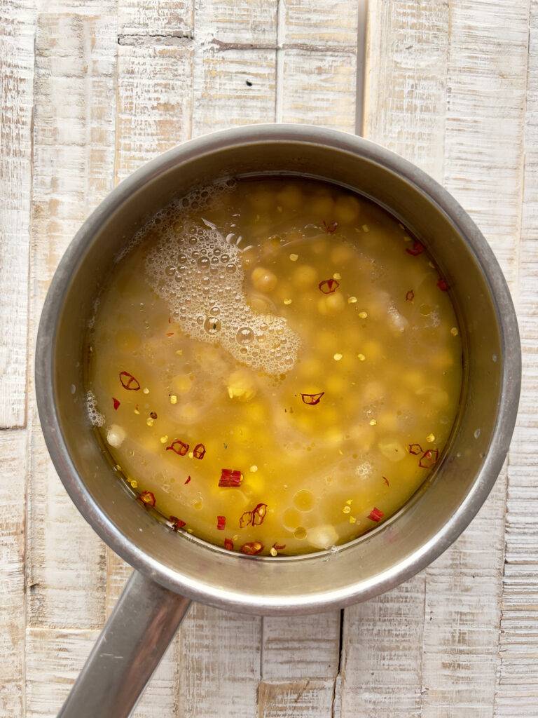 Chickpeas covered in liquid in the stainless steel pot