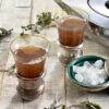 Black tea with sage in two beautiful glasses, with dried sage leaves tossed around them