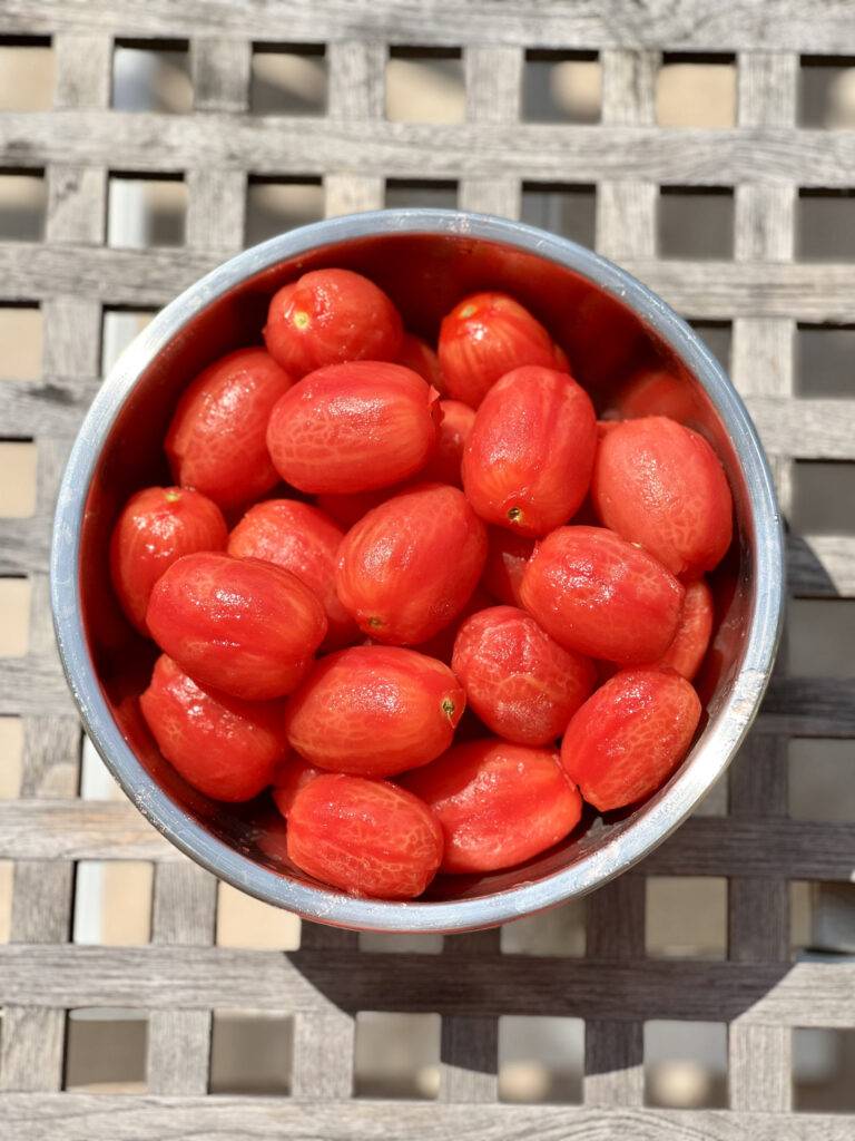 Peeled tomatoes in a stainless steel bowl