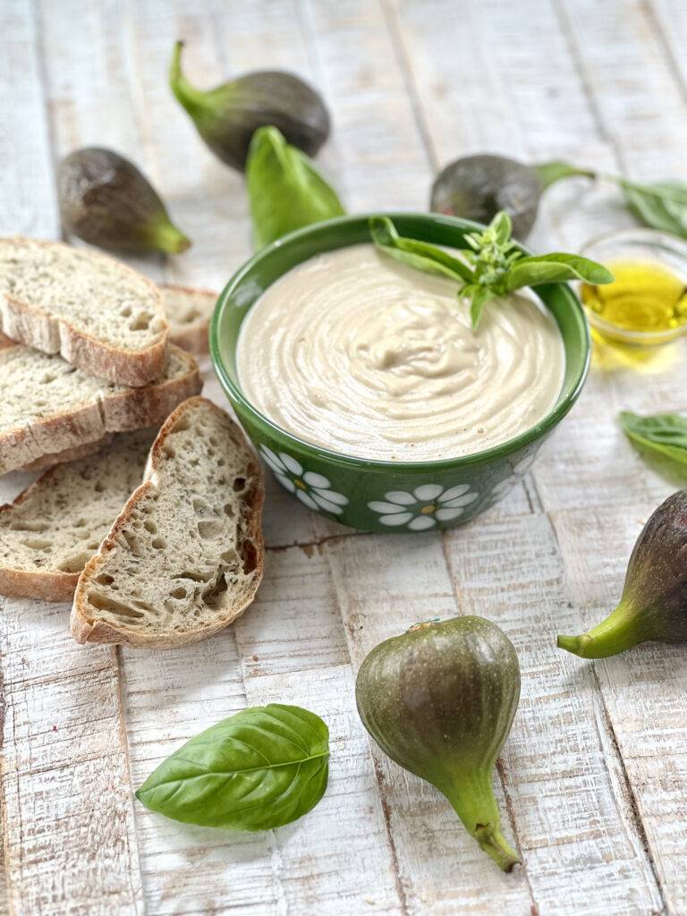A bowl of vegan cashew cream cheese with figs and bread