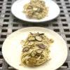 Two beautiful plates of spaghetti alla nerano on a wooden table