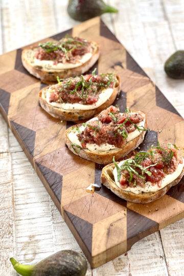 A beautiful wooden board with fig crostini