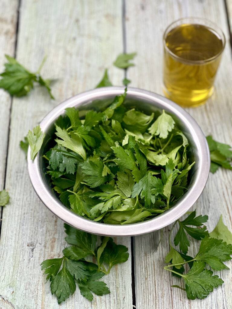 Ingredients for the herb oil recipe (fresh parsley and olive oil) 