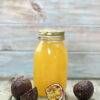Passion fruit water kefir in a fermentation bottle with passion fruits around it