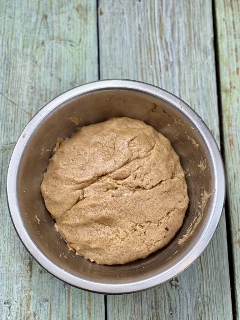 A ball of espresso shortbread dough in a stainless steel bowl
