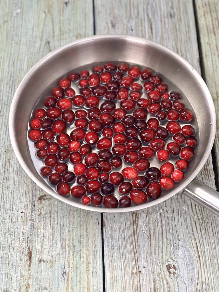 Cranberries with water and sugar in a saucepan