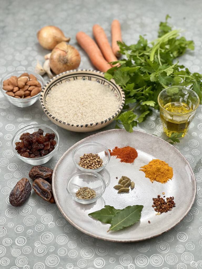 Ingredients for vegan pilaf rice on a beautiful underground. A grey plate with the spices is in the middle and the other ingredients are decorated around