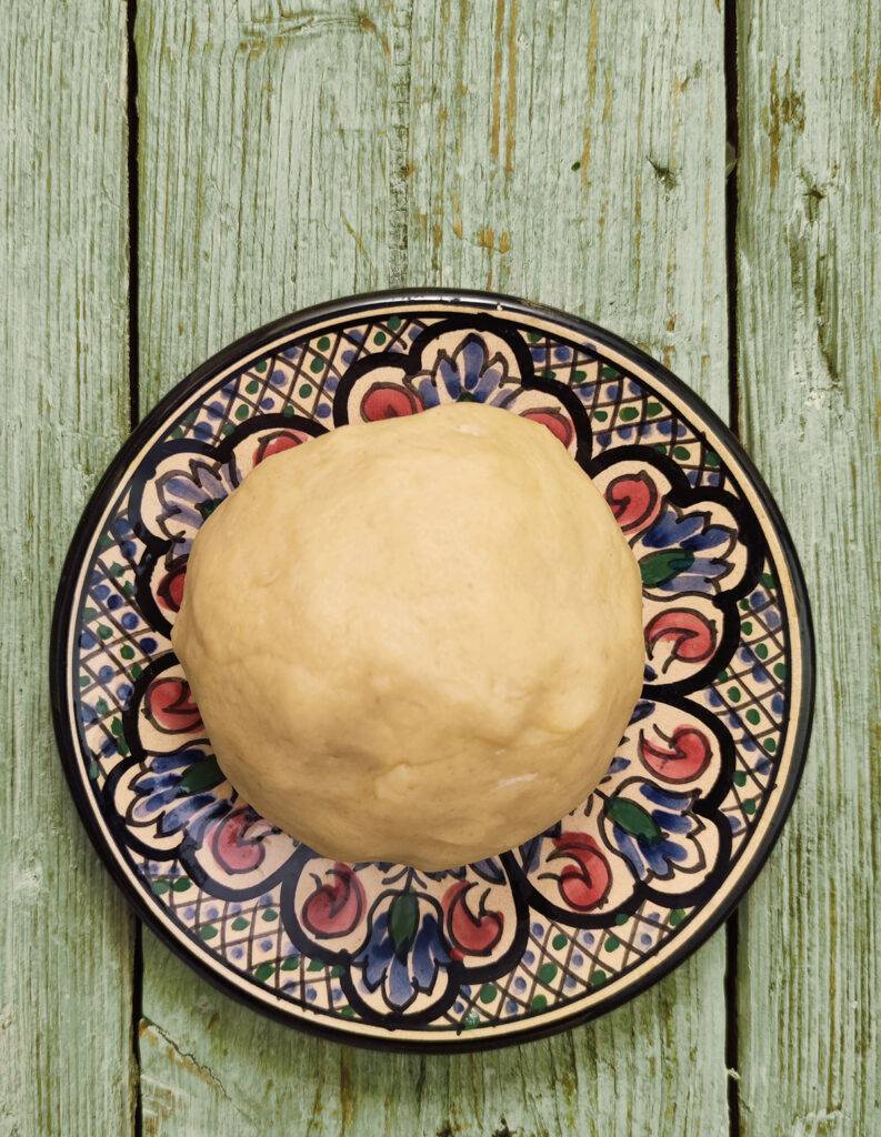 Dough ball on a colourfull plate on wooden underground 