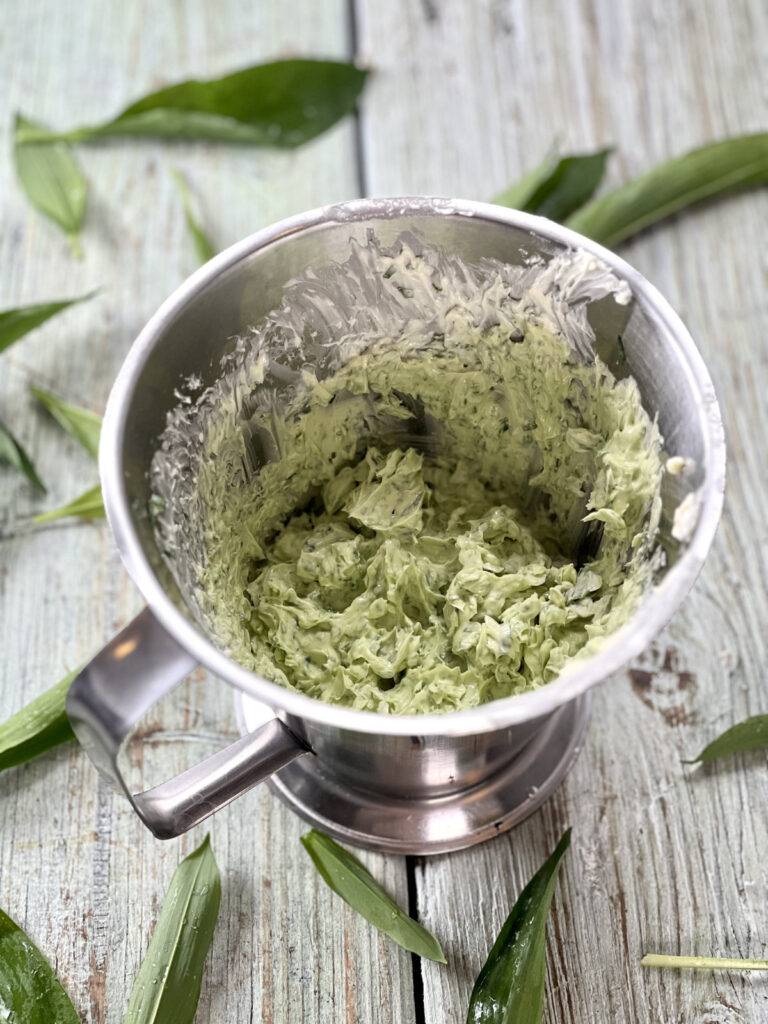 Processed wild garlic butter in a stainless beaker.
