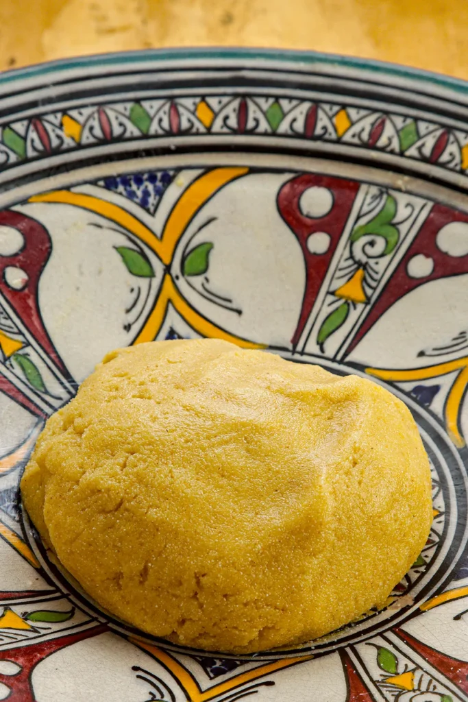 A fully kneaded dough ball for Date cookies is lying in a colorful bowl.