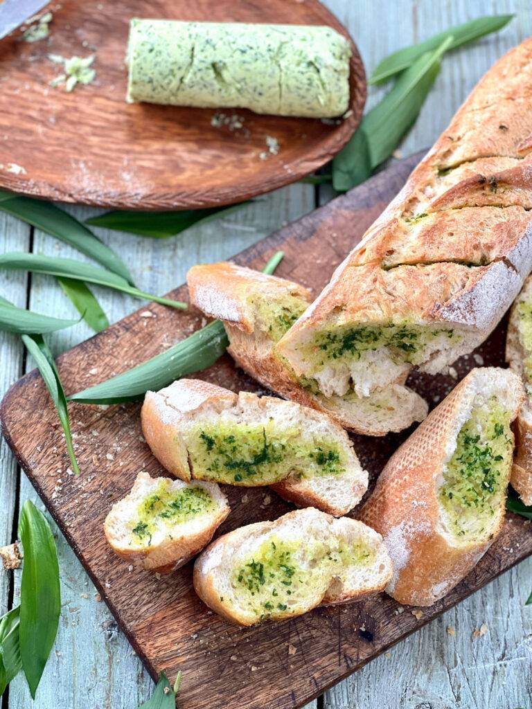 Pieces of sliced wild garlic bread on wooden board
