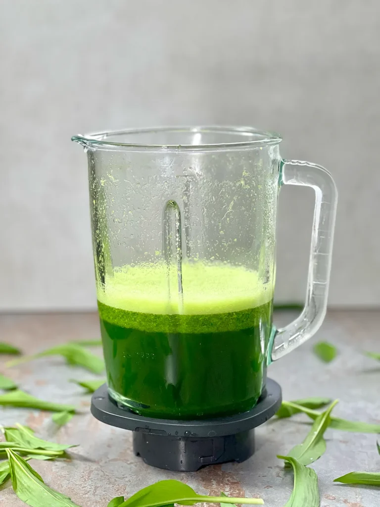 Green wild garlic water for the focaccia dough in a glass blender 