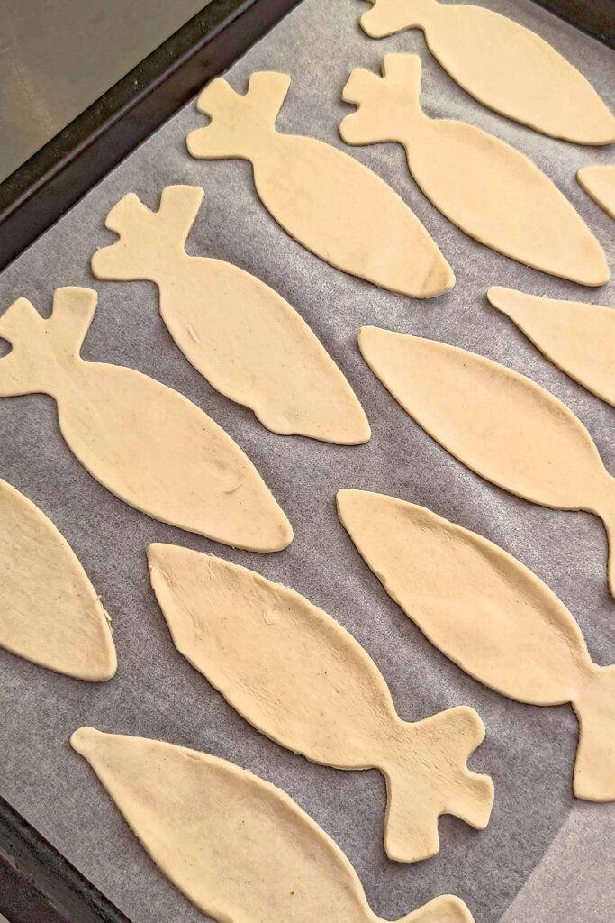 Cut out carrot shapes from puff pastry, placed on baking paper on the baking tray.