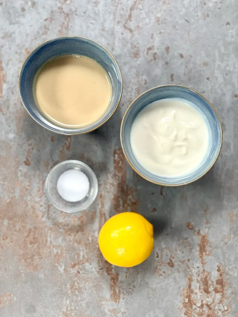Ingredients for yogurt tahini dip in little bowls (Soy yogurt, tahini, lemon, salt)