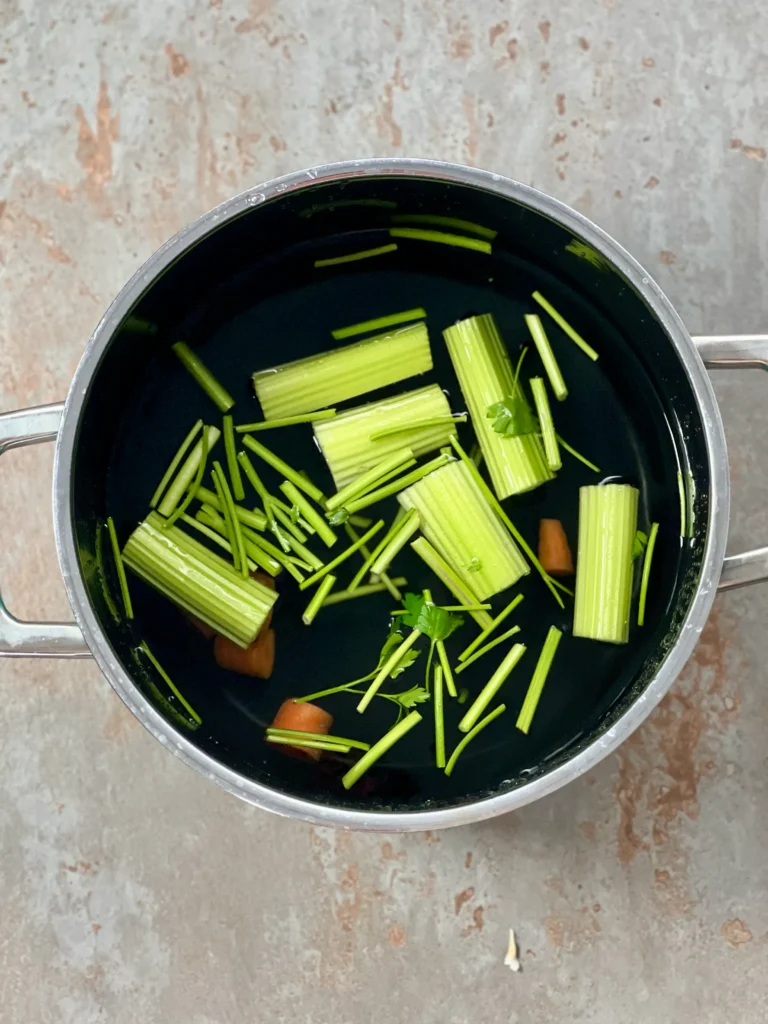 Vegetable stock simmering in a black pot