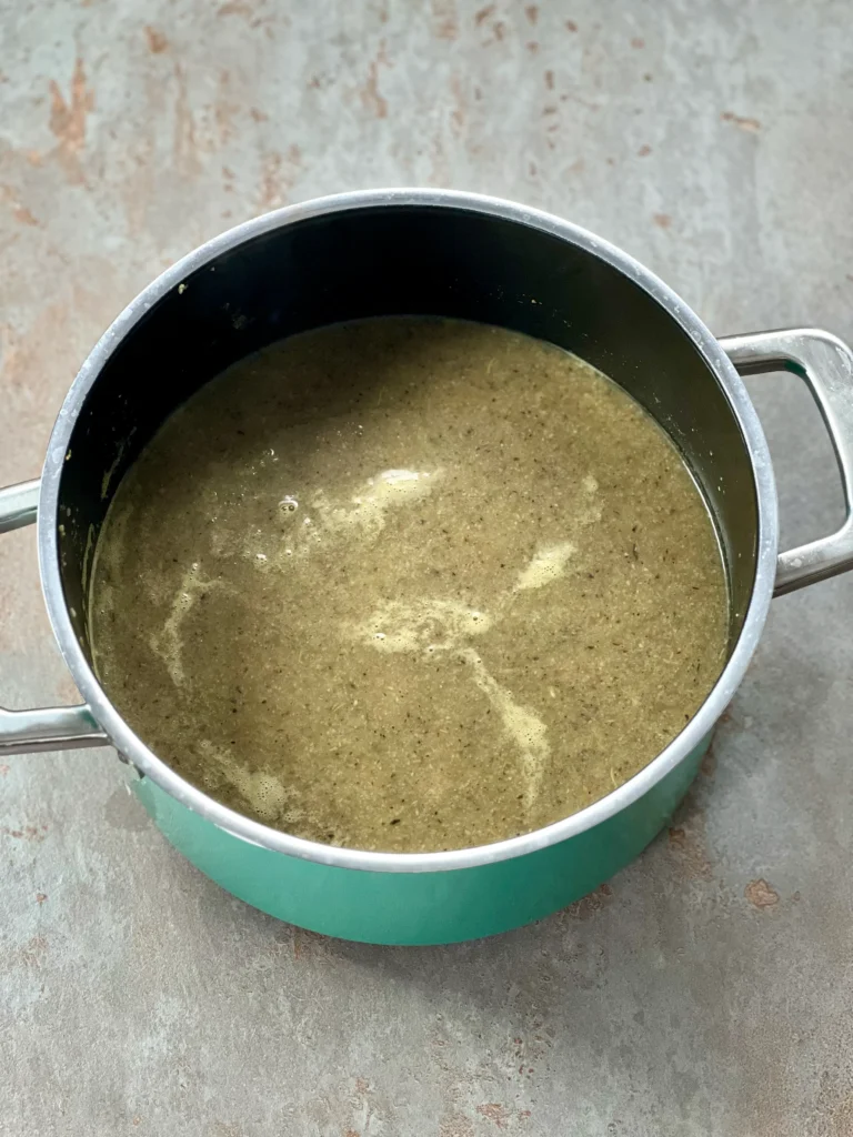 Finished mushroom stock for the risotto in a turquoise pot