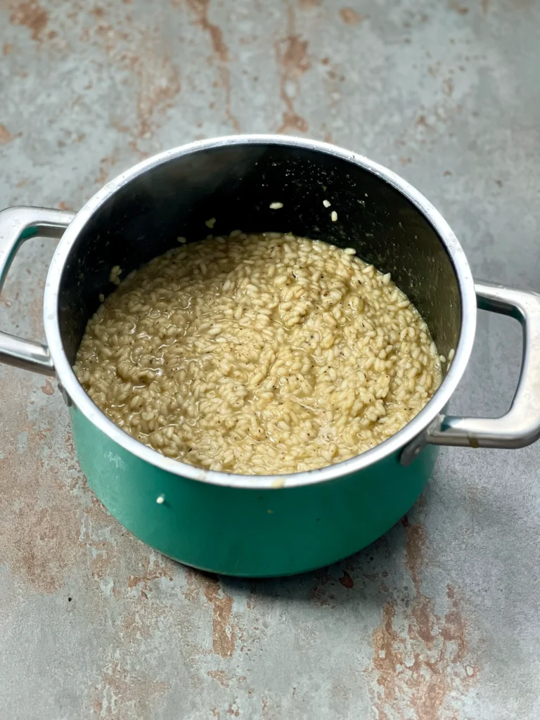 Finished risotto rice cooked with flavorful mushroom stock in a turquoise pot