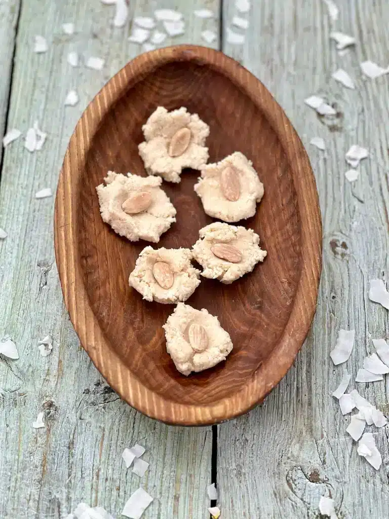 Pressed down coconut trufffle mixture with a blanched almond in the middle of each