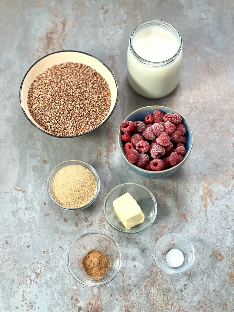 Ingredients for buckwheat porridge in little bowls on a grey stone underground