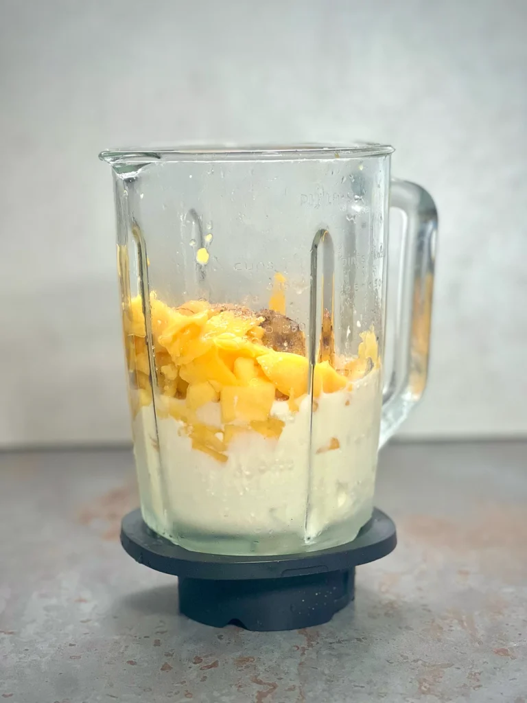 Ingredients for the mango lassi in a glass blender