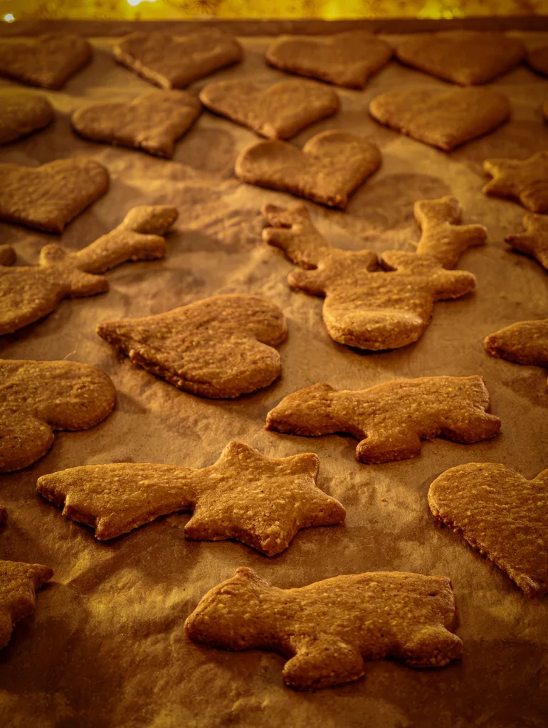 A close look to the gingerbread cookies ready baked, all on baking paper.