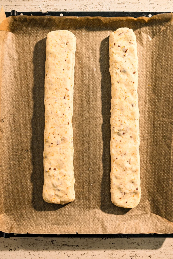 The two dough rolls are placed on a baking tray on baking paper before baked in the oven.