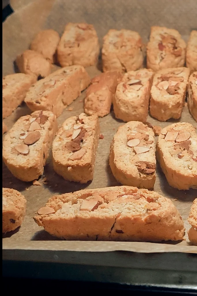 A look on the baking tray with the slices of vegan almond biscotti with orange & marzipan, ready baked.