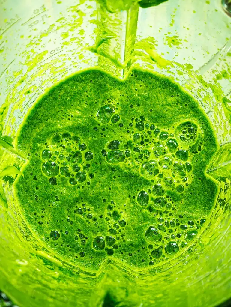 A view from above into the blender of the blended light green wild garlic puree.