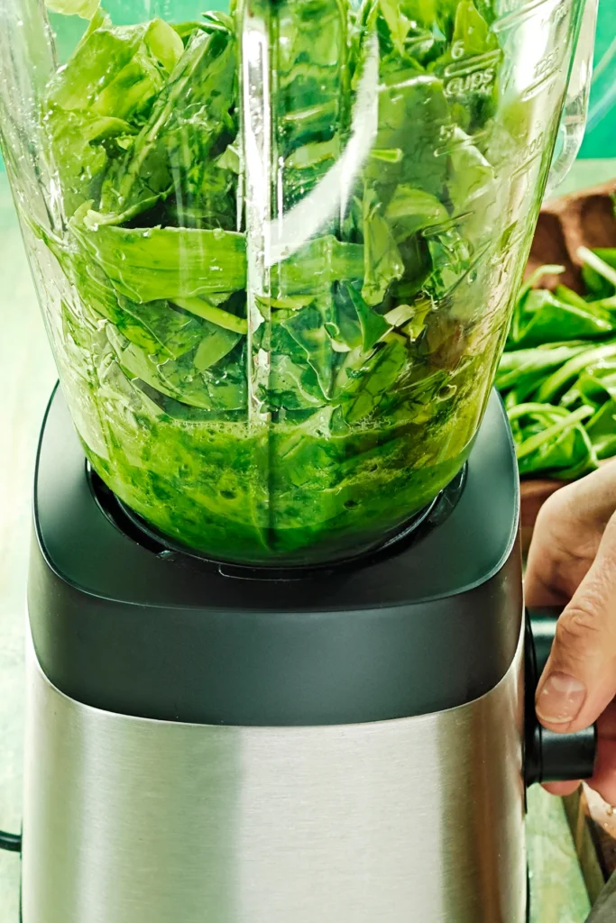 The chopped wild garlic puree is in the blender and is blended to puree.