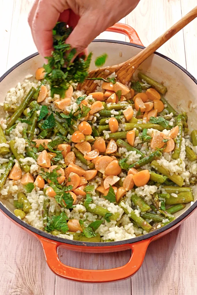 The chopped mint is added to the asparagus risotto with physalis.