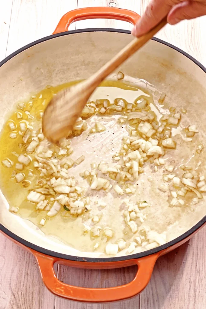 In a high pan, fry the chopped garlic and chopped onion.