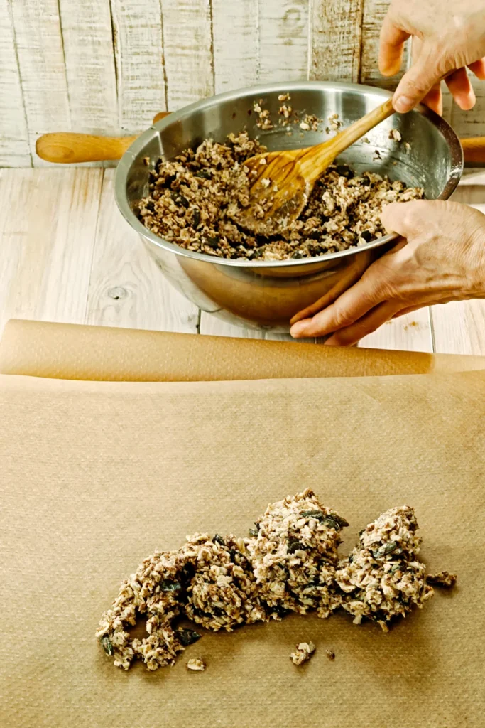 Crispbread dough with seeds is placed on baking paper to be rolled out.