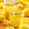 A jar of preserved lemon slices sits behind a screw-top jar of pureed preserved lemons. In front of it is a bowl of lemon puree.
