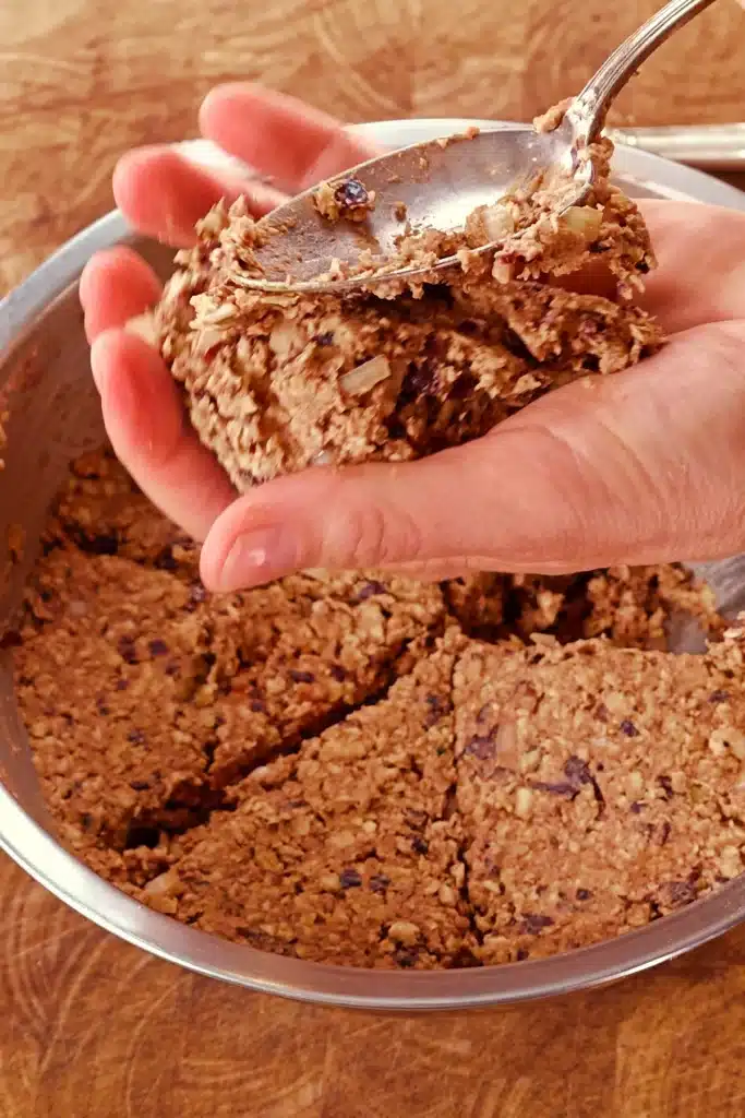 The dough for the BBQ tempeh burger patties is divided into six portions. The first portion is formed into a burger patty in the hand.
