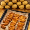 The crispy potato wedges are ready baked on the baking tray.
